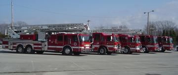 A fleet of fire trucks all parked in a row.