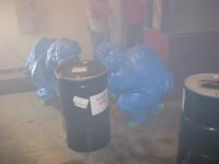 Two people in blue plastic suits handling hazardous materials.