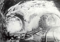 Black and white photo of an underground train track.