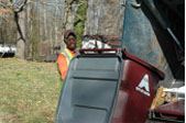 A worker loading trash onto a truck.