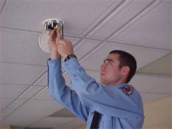 A firefighter installing a smoke detector.