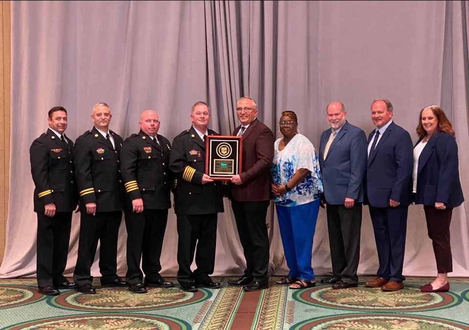 Photo of AFD employees and commissioners receiving placard of reaccreditation 