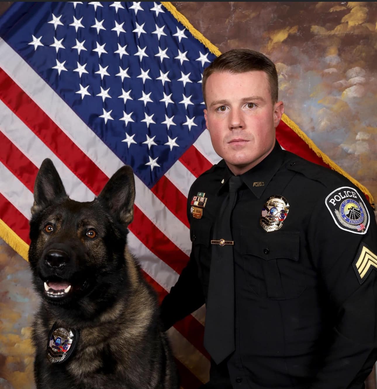 Sergeant Moore posed with K9 Unar in front of American Flag background